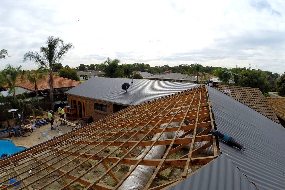 Tile to Colorbond roof replacement in progress: old tiles removed, new battens fitted and new Colorbond sheets going on